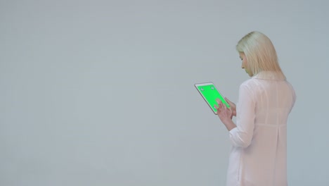 doctor pressing the green screen of a tablet computer against white background