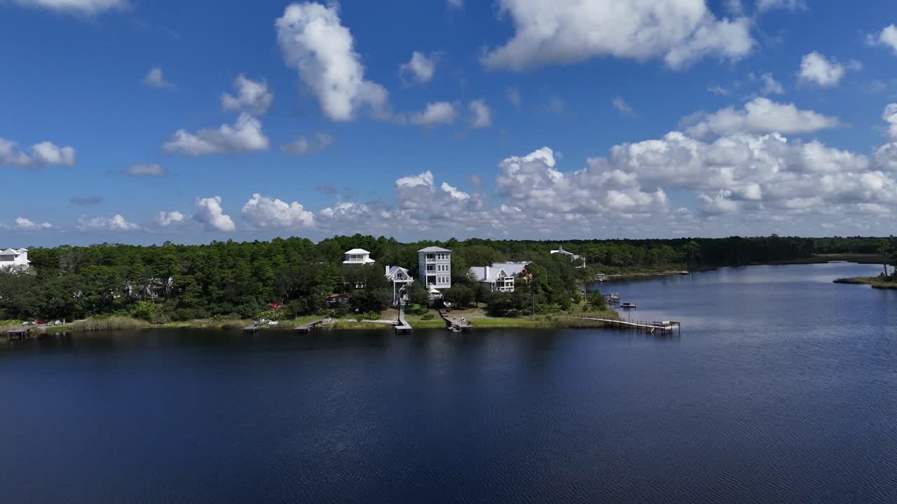 Fast drone fly to the one of the white coastal and luxury house at calm Camp Creek Lake, 30A, Florida, USA