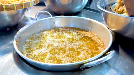 hot oil boiling in pan at bangkok floating market stall
