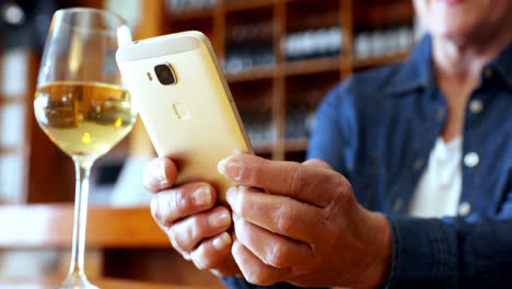 hombre teléfono móvil mientras tiene vino en el bar 4k