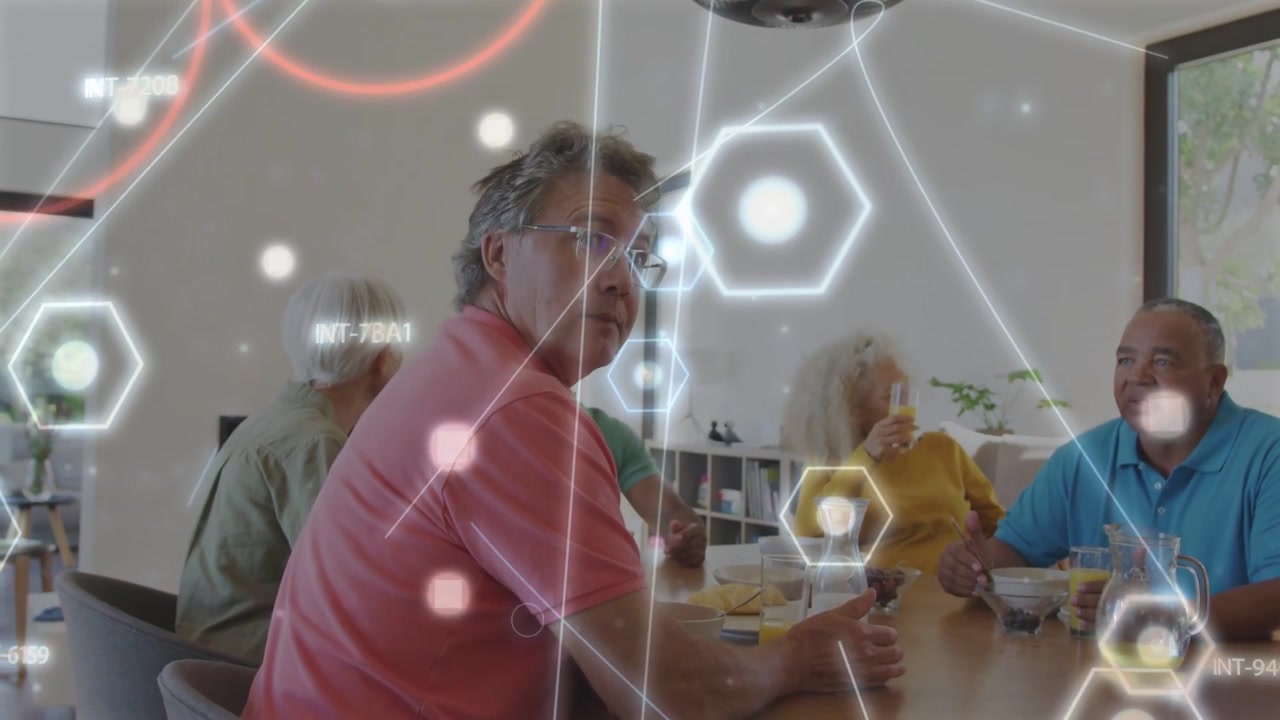 Uomo in polo rosa che parla e gesticola, gruppo che conversa con esagoni tecnologici che oscurano parzialmente i volti