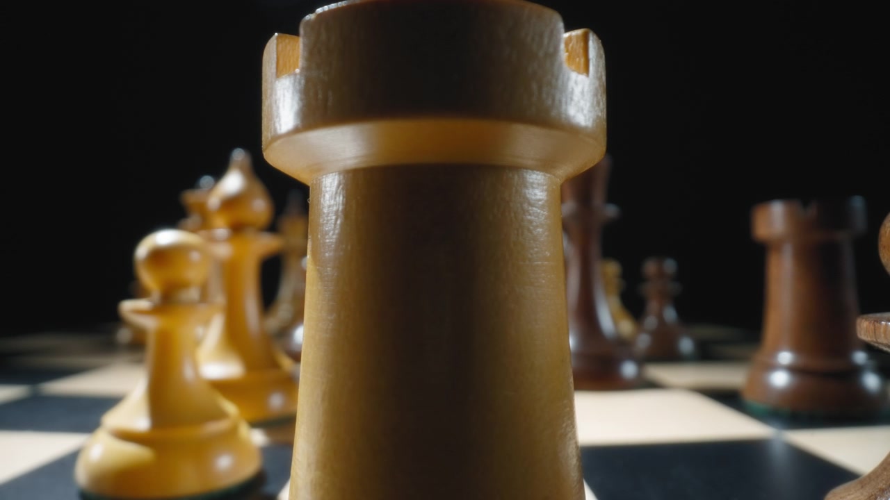 Macro dolly shot of a white castle chess piece on a chessboard