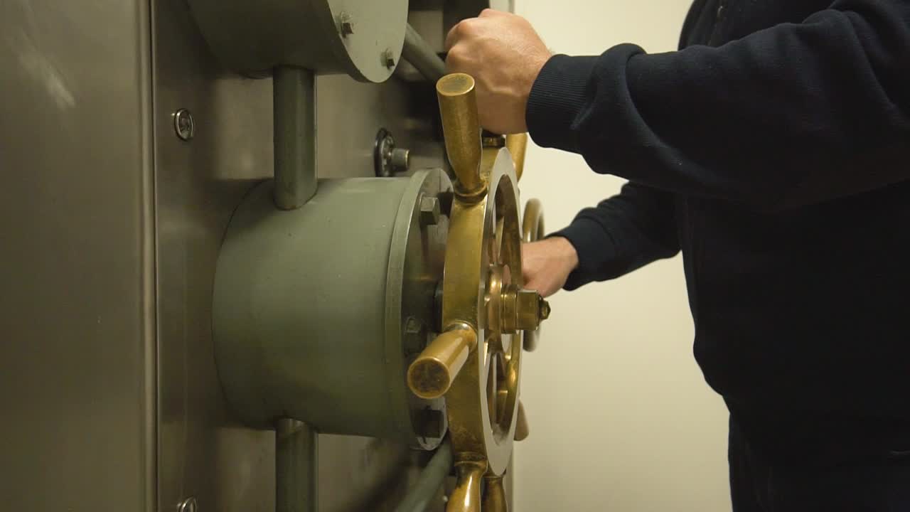 el hombre cierra una gran puerta de caja fuerte del banco, dinero seguro, puertas pesadas de acero cuentas bancarias