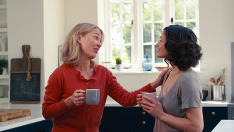 Liebevolles-Gleichgeschlechtliches-Reifes-Weibliches-Paar,-Das-Gemeinsam-Kaffee-Trinkt-Und-Sich-In-Der-Küche-Umarmt