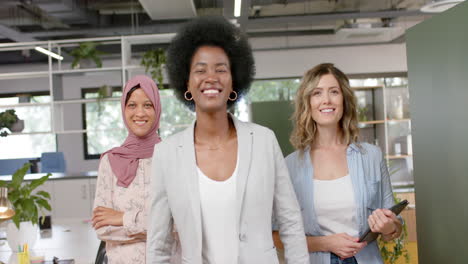 Portrait-of-happy-diverse-creative-female-colleagues-with-tablet-in-office,-slow-motion