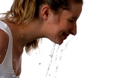 woman splashing her face on white background