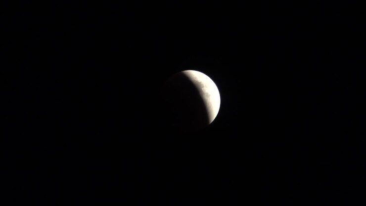 Partial Lunar Eclipse in Dark Night Sky