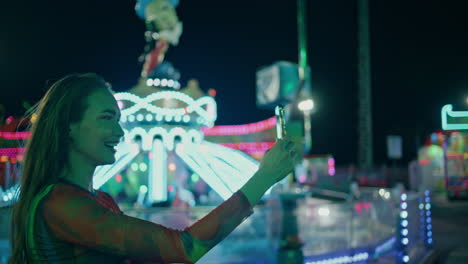 happy girl recording selfie video at amusement park. smiling teenager streaming