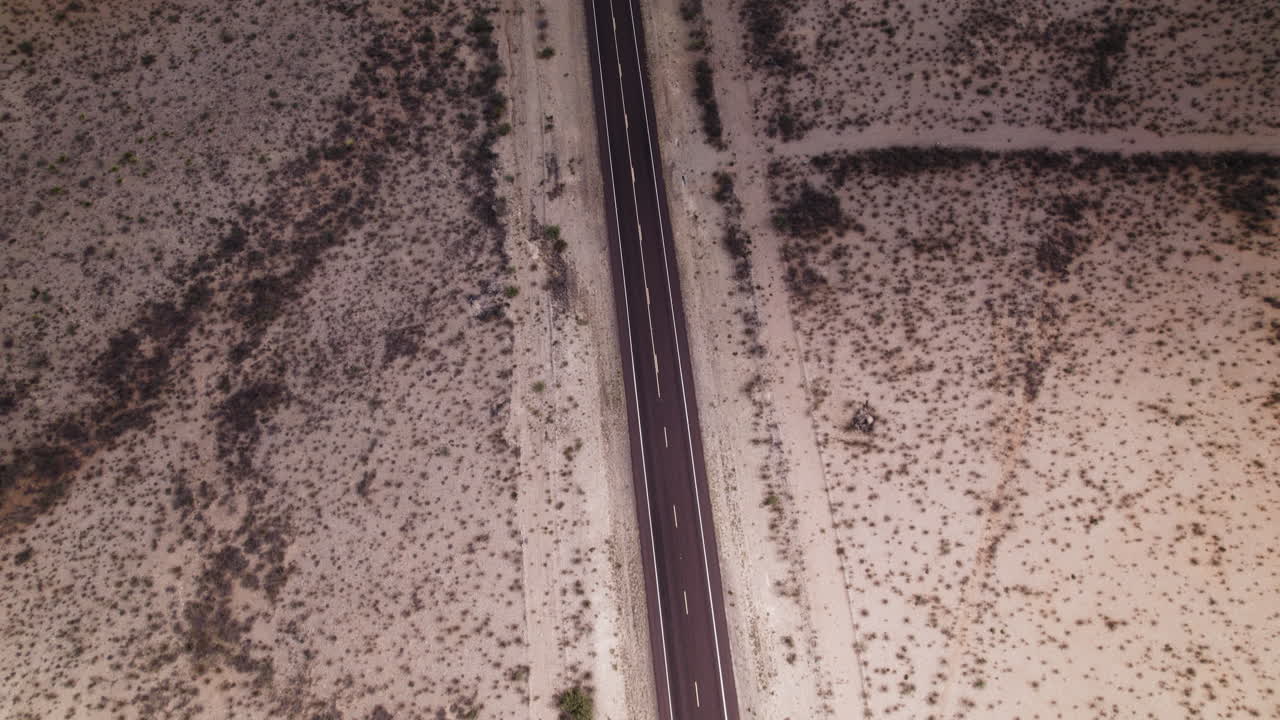Aerial view of an empty stretch of desert highway near Big Bend in west Texas tilts up to horizon