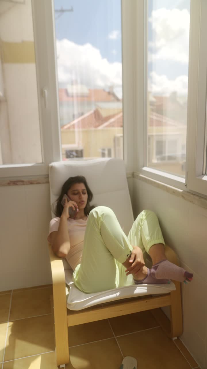 Teenage girl talking on phone on a balcony