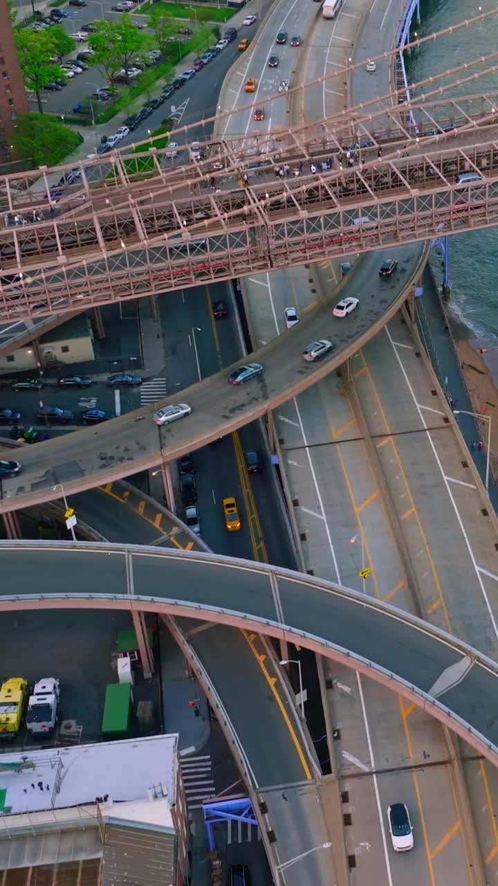 Road junctions under Brooklyn bridge. Busy traffic of New York city. View from above. Vertical video