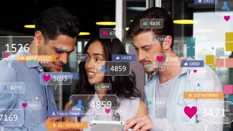 Animation-Von-Social-Media-Symbolen-über-Verschiedenen-Kollegen,-Die-Im-Büro-über-Ein-Digitales-Tablet-Diskutieren