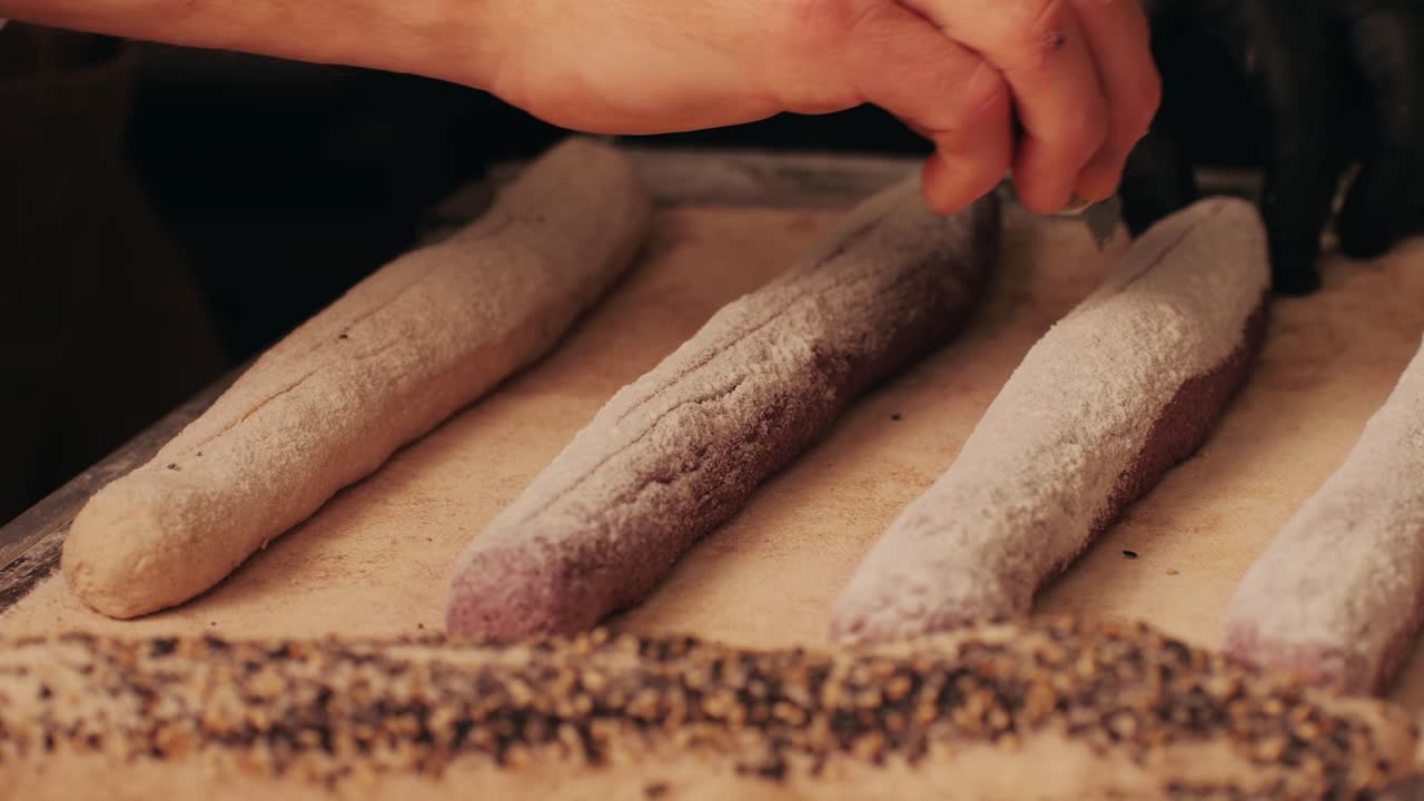 Bakery chef making fresh Artesian buns and baguettes using traditional recipe close-up. Young man kneading dough. Artisan bread is making by skill bakers using natural and high-quality ingredients. Food with health and flavour benefits. Bakery shop and market