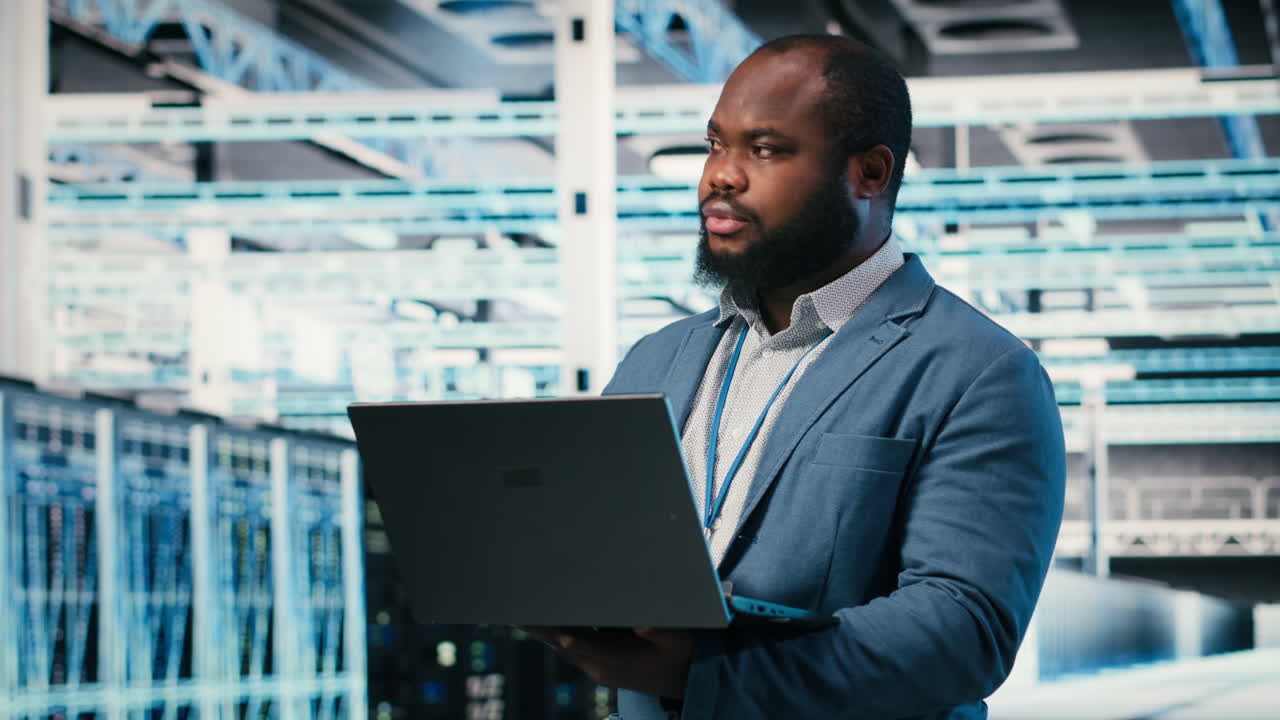 Professional Man Using Laptop in Modern Data Center
