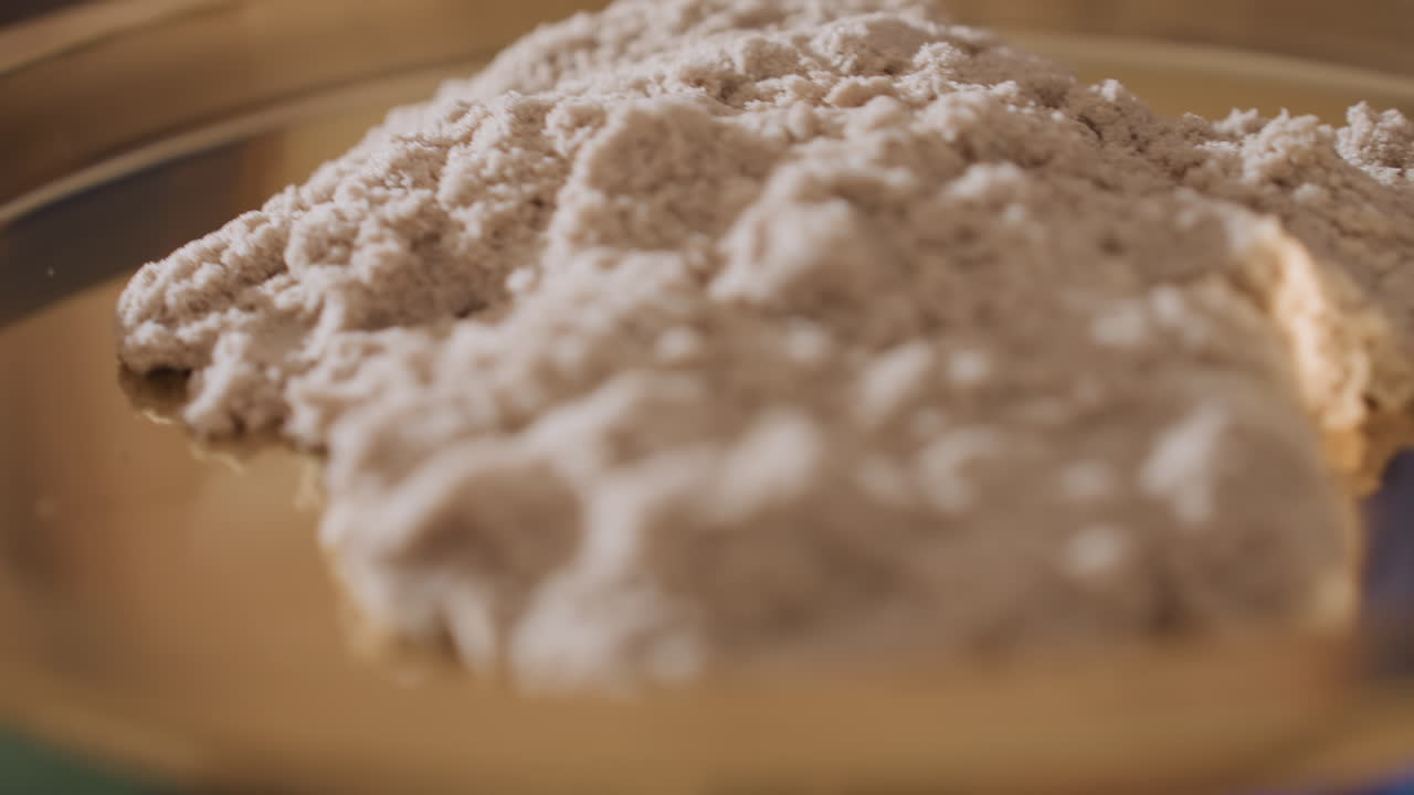 Close up view of soft mold clay on gold tray for creative therapy resting on counselor hand offering tactile sensory experience in calming session environment with reflective focus and mindful posture