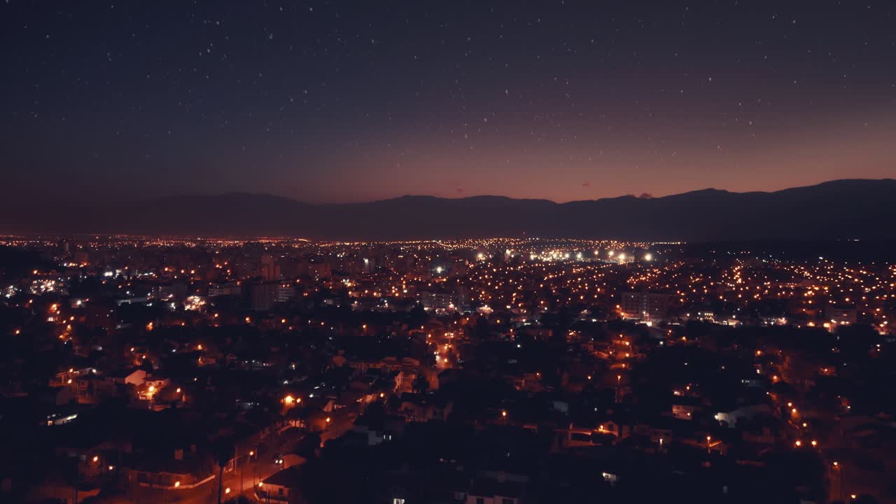 Vista aérea das luzes da cidade e do céu estrelado à noite