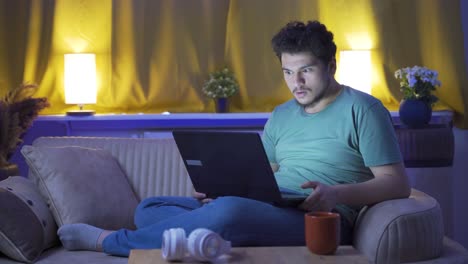 hombre mirando la computadora portátil con sorpresa por la noche en casa. sorprendido por lo que vio en la computadora portátil.