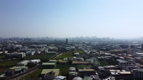 a sprawling urban landscape under clear skies, hinting at bustling city life, aerial view