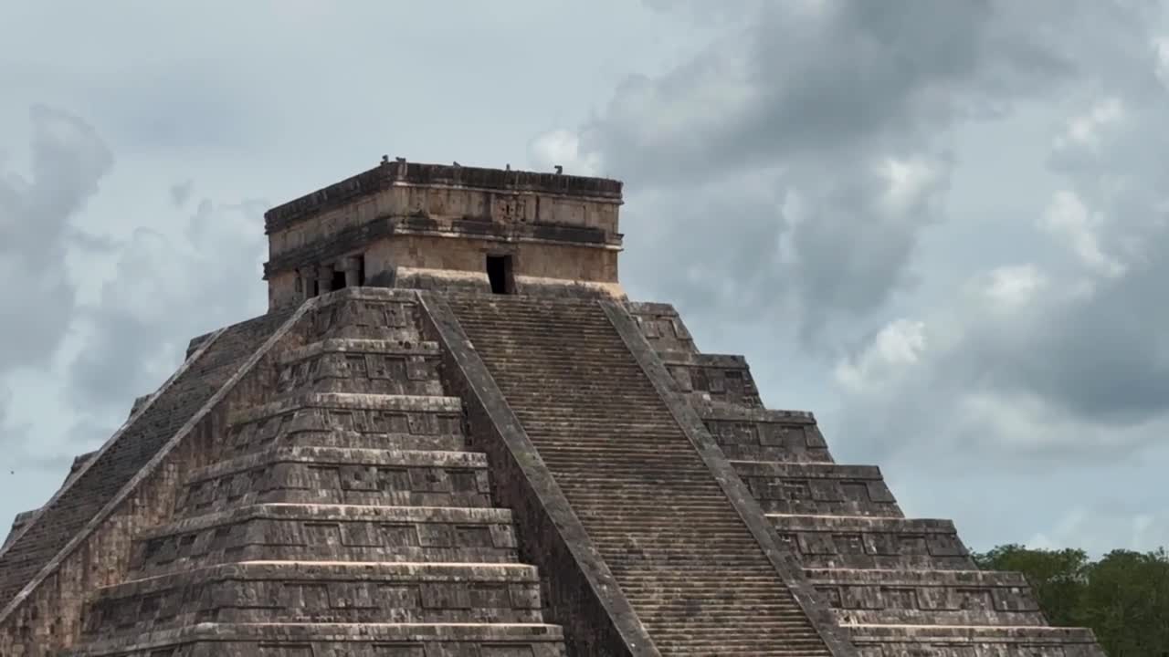 Handheld panning shot revealing the ancient Mayan pyramid of Kukulkan at Chichen Itza in Yucatan, Mexico. 4K