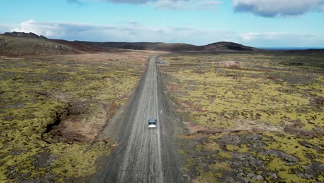 sea testigo de los paisajes islandeses a través de un avión no tripulado, vea coches blancos en carreteras sinuosas a través de terrenos volcánicos escarpados, en un viaje a través de la belleza cruda de islandia