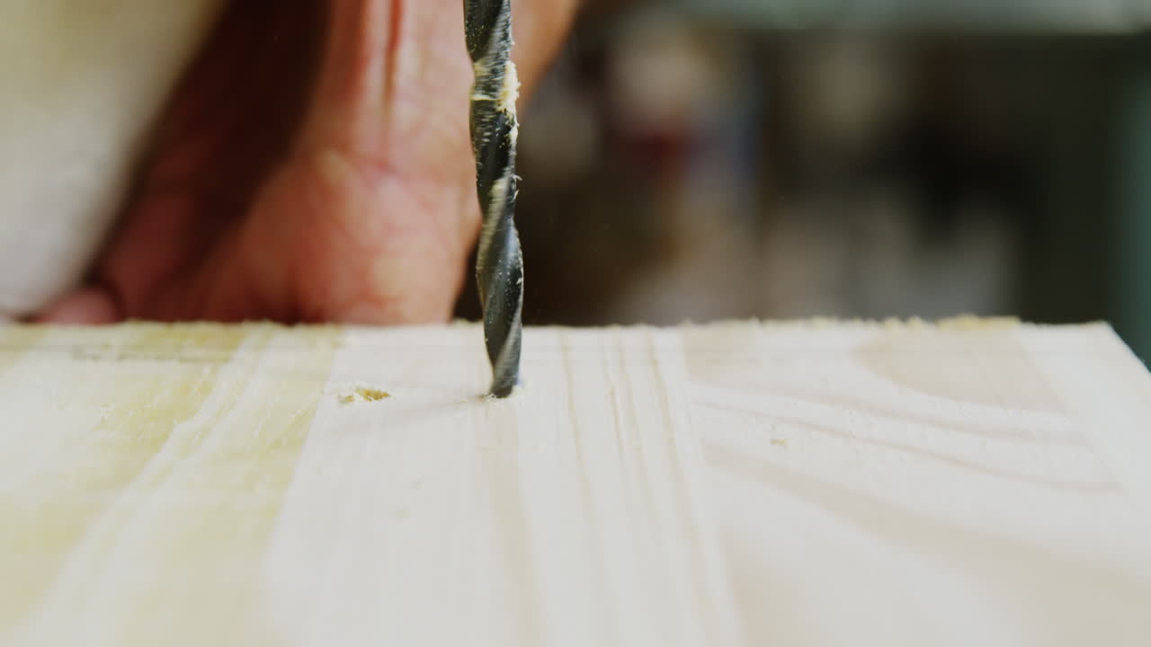 centrarse en un taladro perforando un todo en una tabla de madera