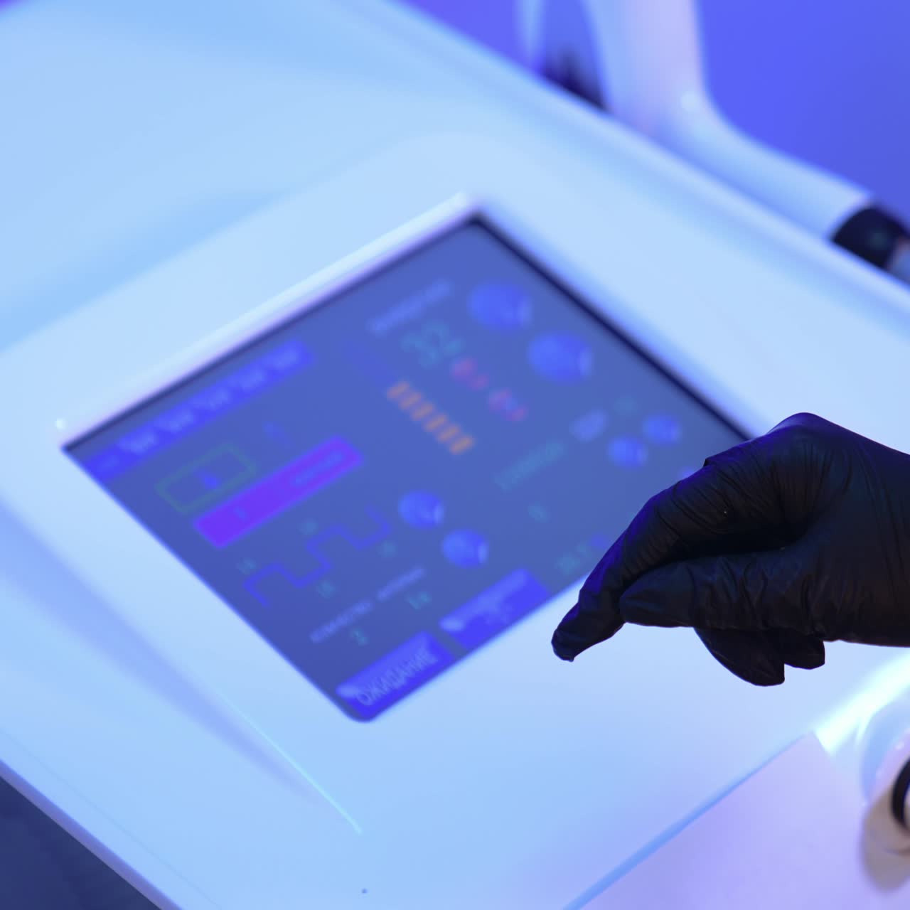 Gloved cosmetologist's hand chooses the necessary parameter on the sensor screen of equipment. Beautician prepares laser for usage