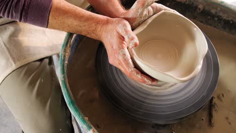 mid section of potter making pot