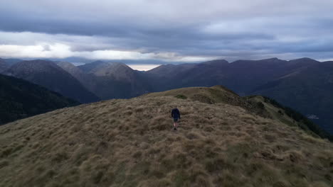 Disparo-De-Drone-De-Una-Mujer-Caminando-Con-Su-Perro-En-Una-Cordillera