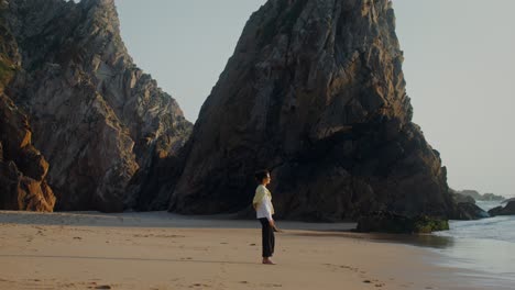 mujer caminando por una playa al atardecer