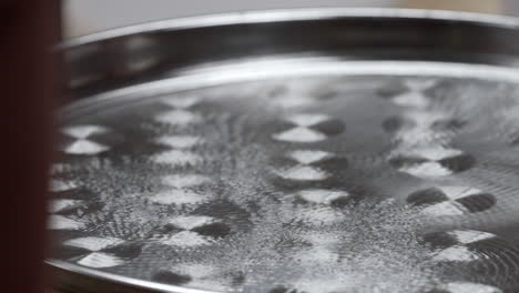 a chladni plate containing water used for therapeutic sound bathing in the sacred valley, cuzco region, peru - close up