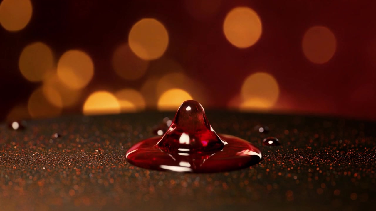 Red Liquid Drop Forming a Crown Shape on Dark Surface