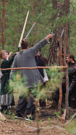 brave warriors raise up swords at training in fir wood slow motion. historical events reconstruction club. battle with old armour to have fun