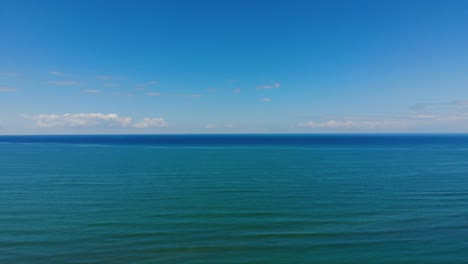 horizonte marino de agua azul turquesa que toca el cielo brillante y las nubes blancas en un día de verano