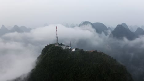 4k drone zoom out mountains around tv tower above the misty clouds guilin