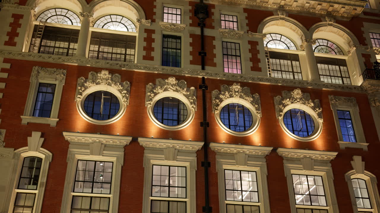 Low-angle view of a grand historical building in London, England with cloudy skies in the background in the evening