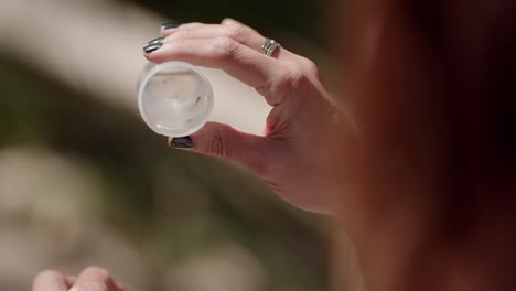 niña bióloga sosteniendo un recipiente de agua y un renacuajo