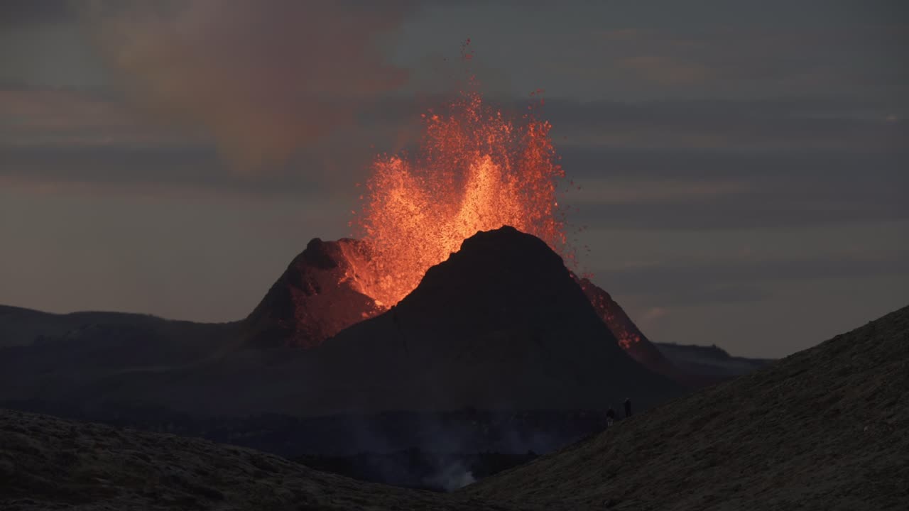 Spectators watching powerful eruption at dusk Iceland