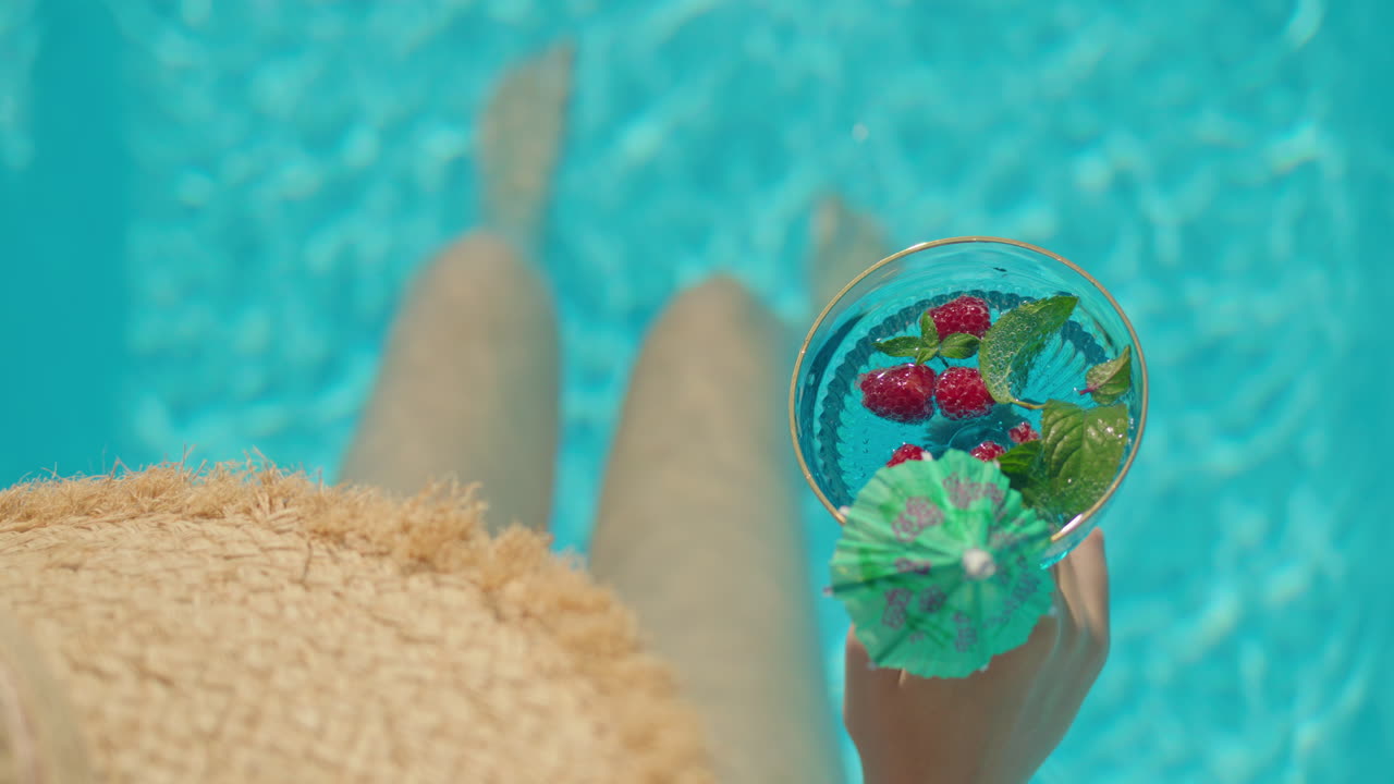 Woman enjoying a refreshing cocktail in a swimming pool