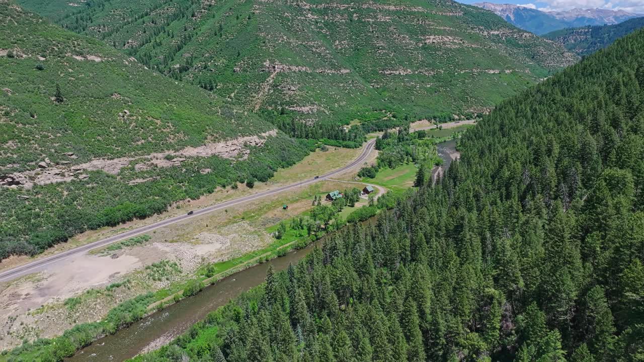 volando a lo largo del río slate y un valle boscoso con una carretera en el medio cerca de la, colorado, ee.uu.
