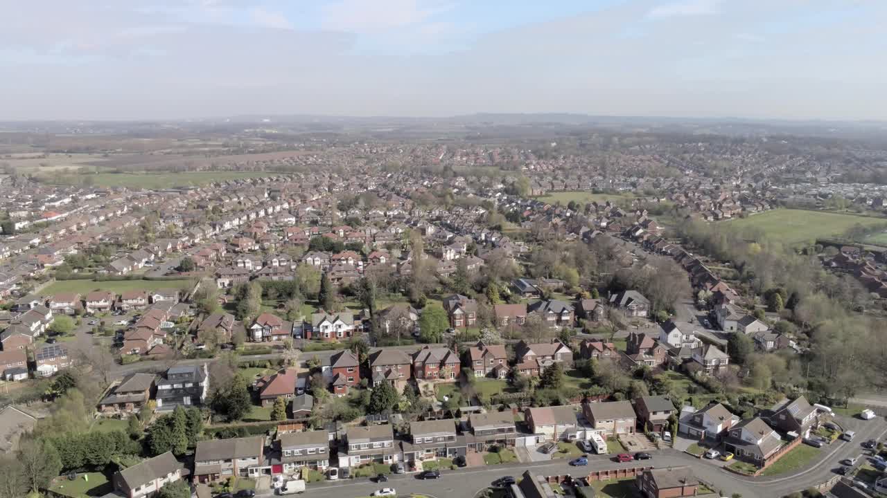 Typical aerial view countryside townscape town houses residential British farmland fields slow pull back