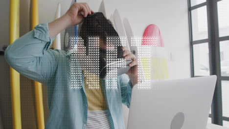Adjusting hat, man working on laptop with digital animation overlay