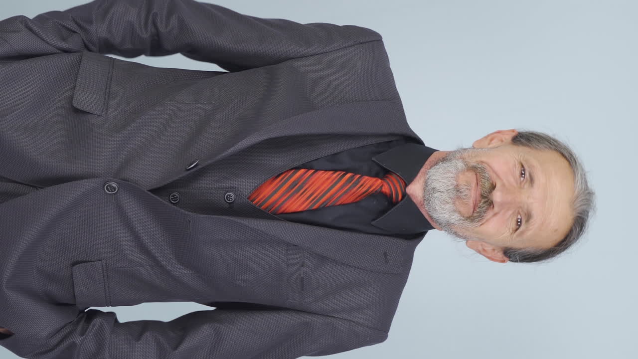 video vertical de un viejo hombre de negocios riéndose de la cámara.