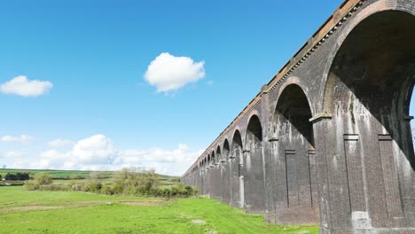 Niedriger-Drohnenflug-Entlang-Der-Bögen-Des-Welland-Viadukts-In-Northamptonshire,-Auch-Bekannt-Als-Harringworth--Und-Seaton-Viadukt-An-Einem-Sonnigen-Tag