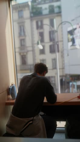 person working at a cafe with a city view