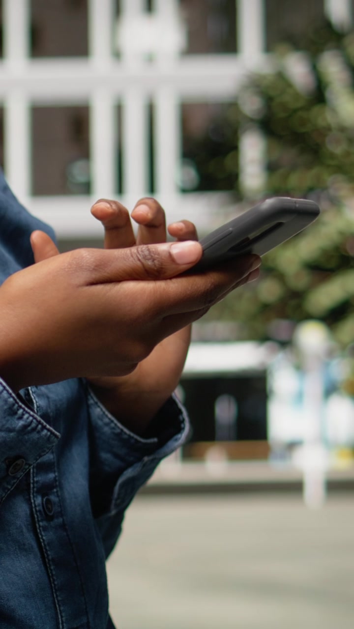 Video verticale: primo piano di una donna di colore che usa lo smartphone per orientarsi con un'app.