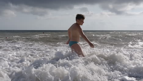 boy playing in the waves