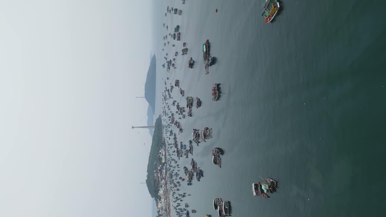 Vertical Shot Of Boats Sailing At The Sea Nearby Sunset Town In Phu Quoc, Vietnam. aerial, rotating shot