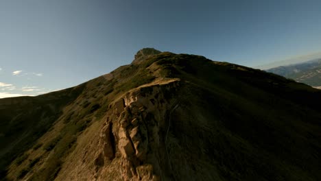 fpv flight along rocky summit of mountain bondone during golden sunset in dolomites