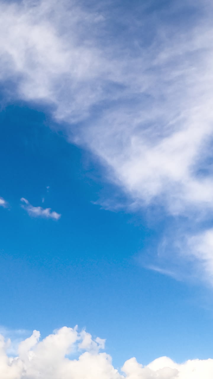 Azure skies with floating soft light clouds. Summer day cloudscape from low angle view. Timelapse. Vertical video