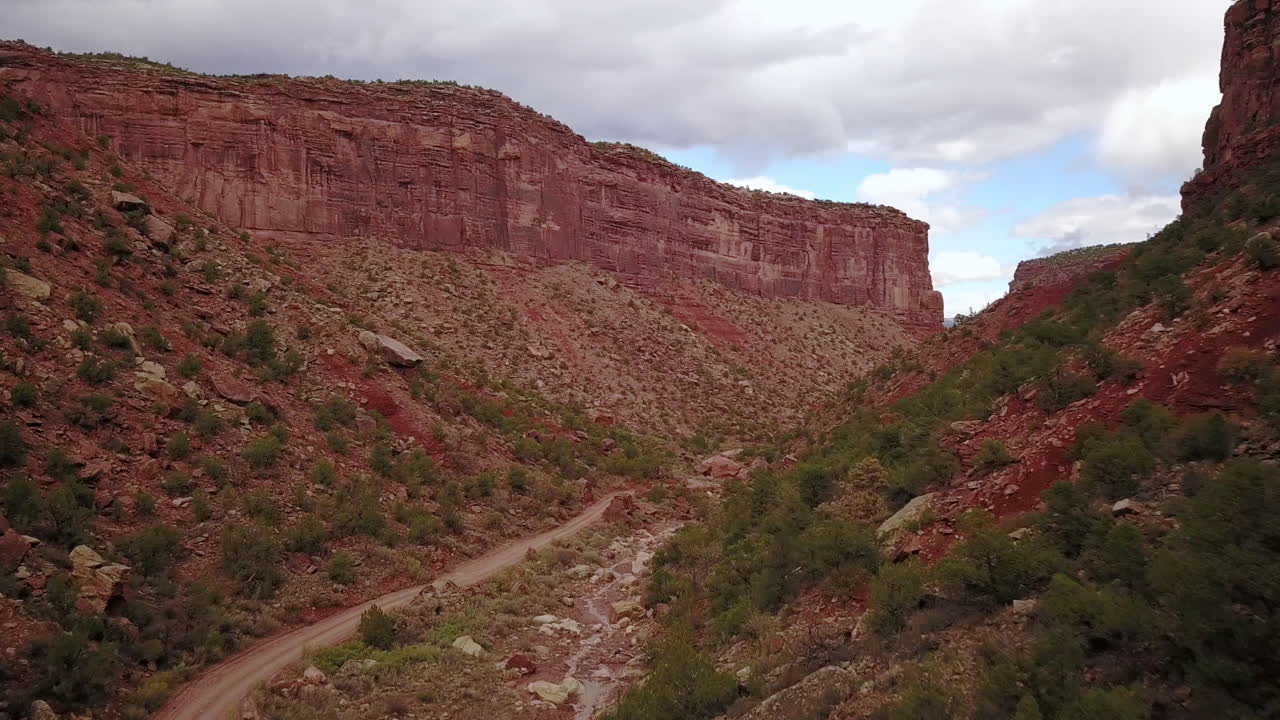 antena de camino de tierra con butte mesa flat top mountain en un hermoso día en el desierto suroeste de colorado, ee.uu.